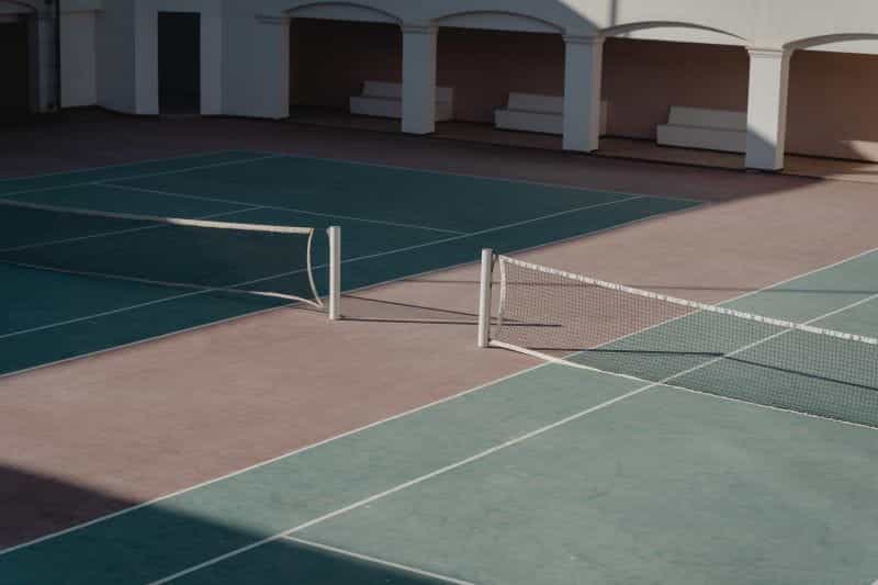 An empty tennis court in the daytime.