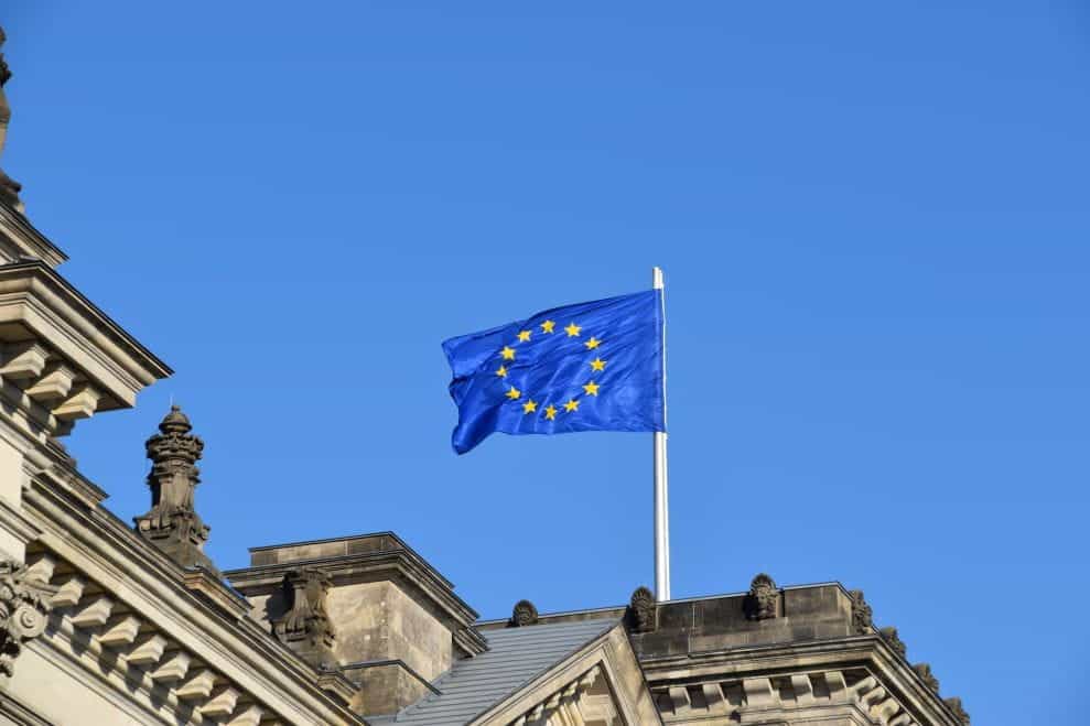 An EU flag mounted to the top of a building.